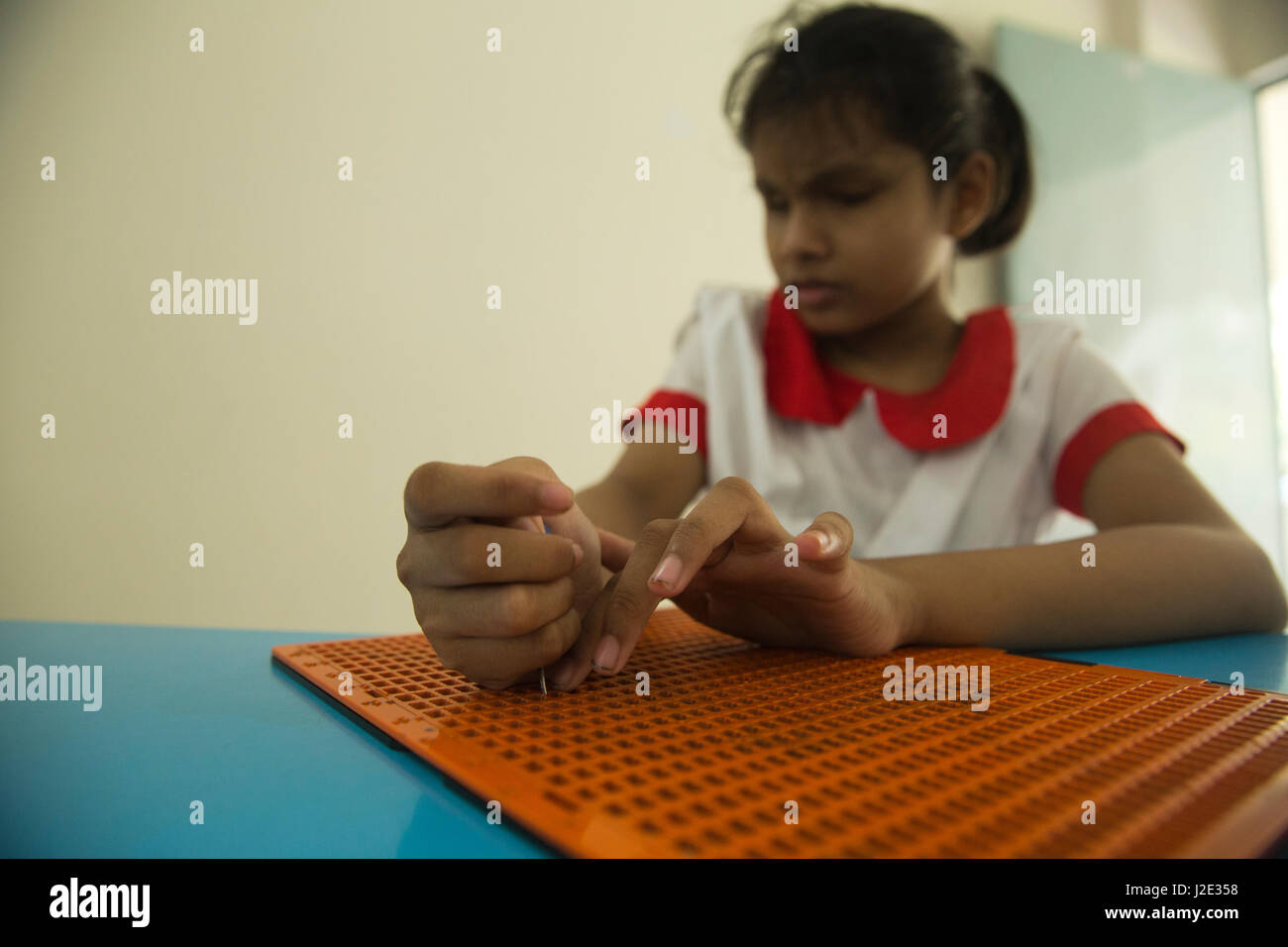 Visually impaired girl student learns in classroom with the help of