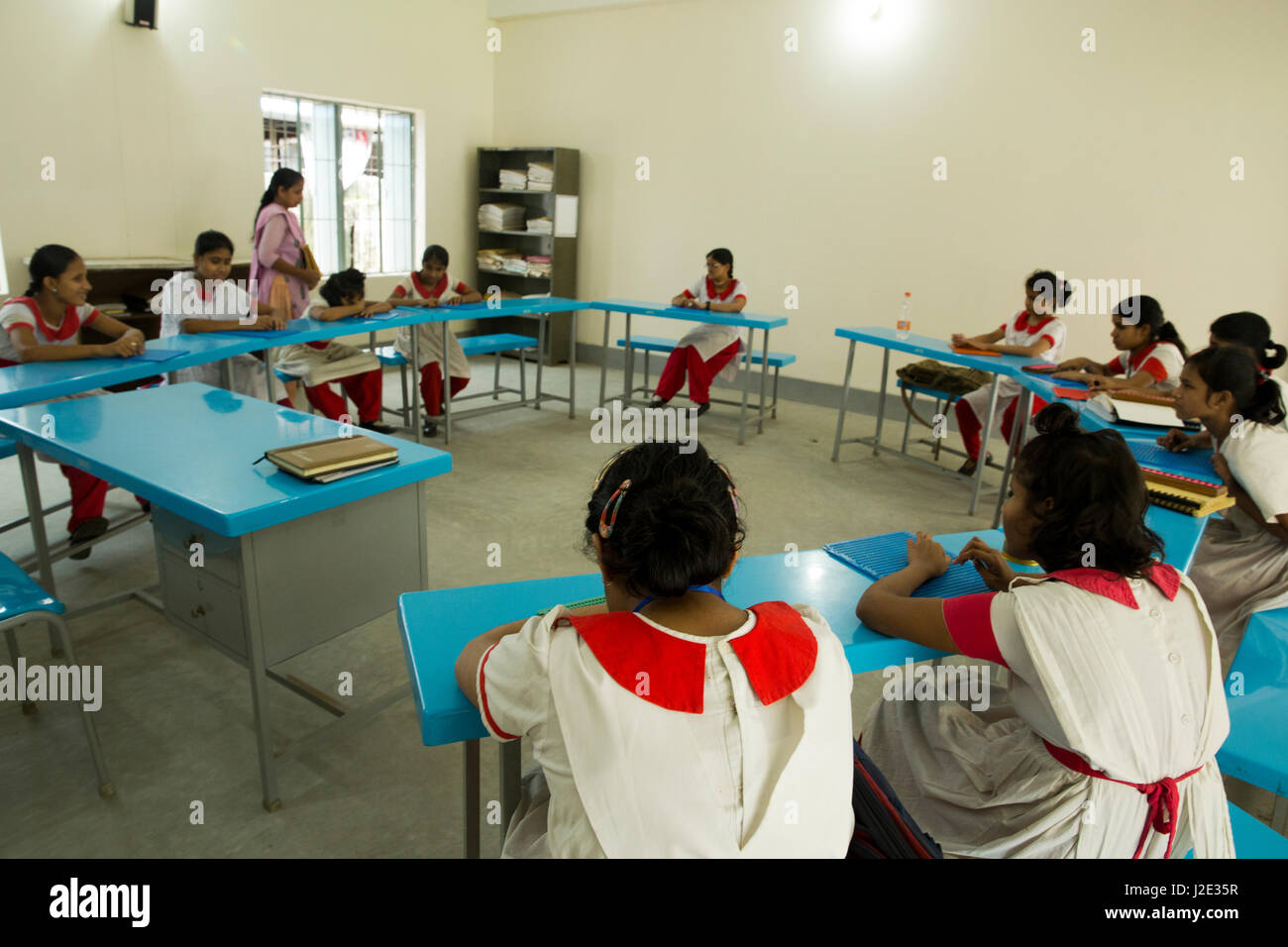 Visually impaired girl students learn in classroom with the help of