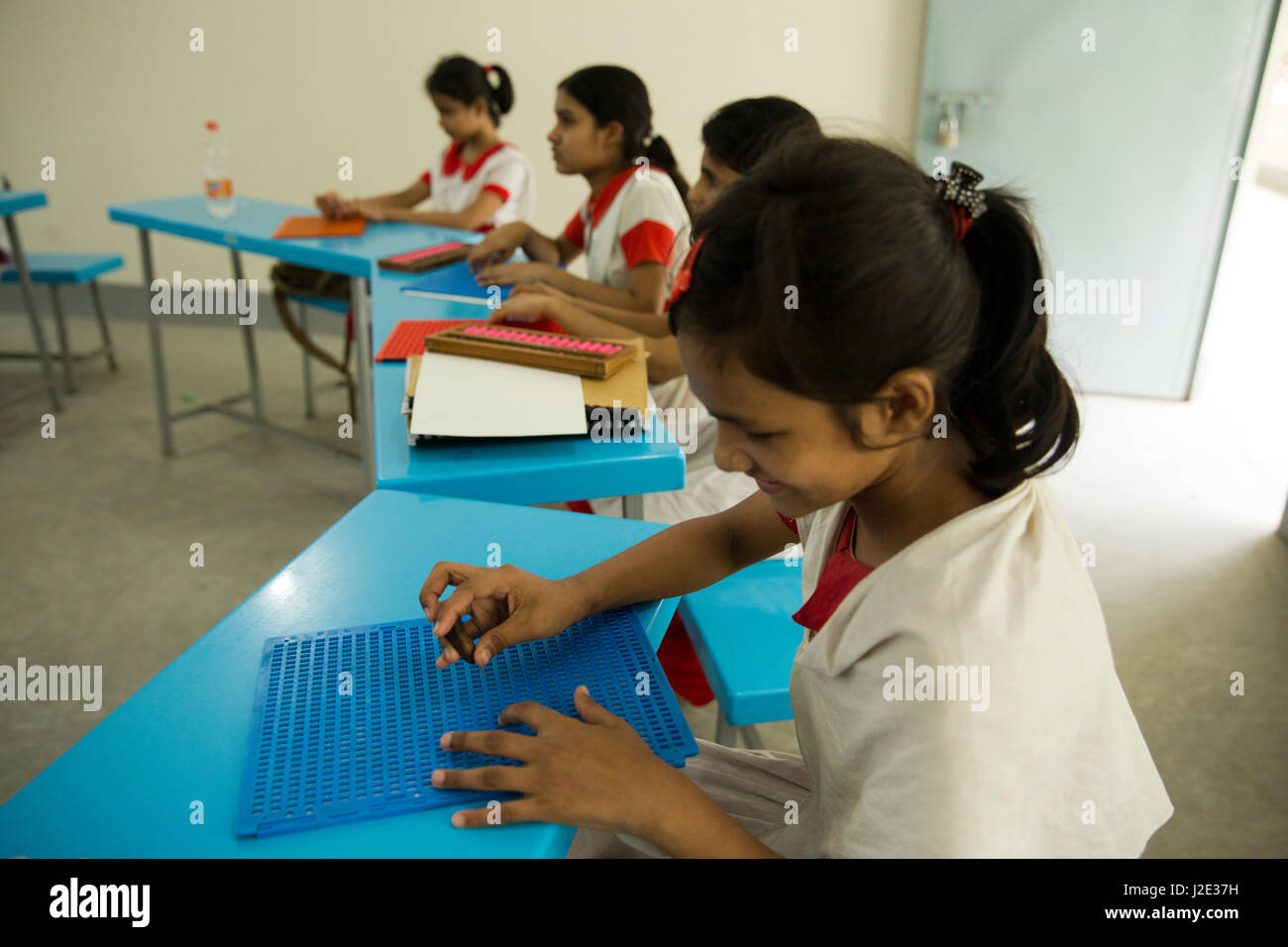 Visually impaired girl students learn in classroom with the help of