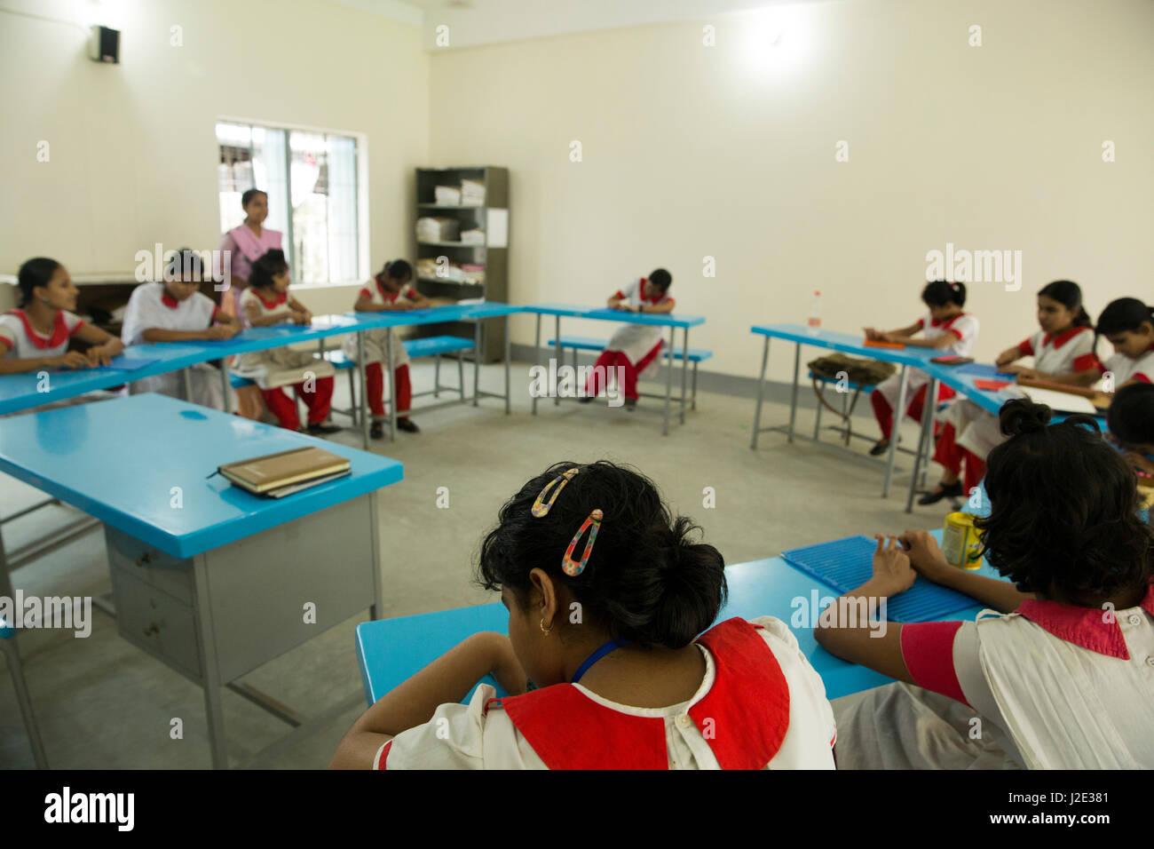 Visually impaired girl students learn in classroom with the help of