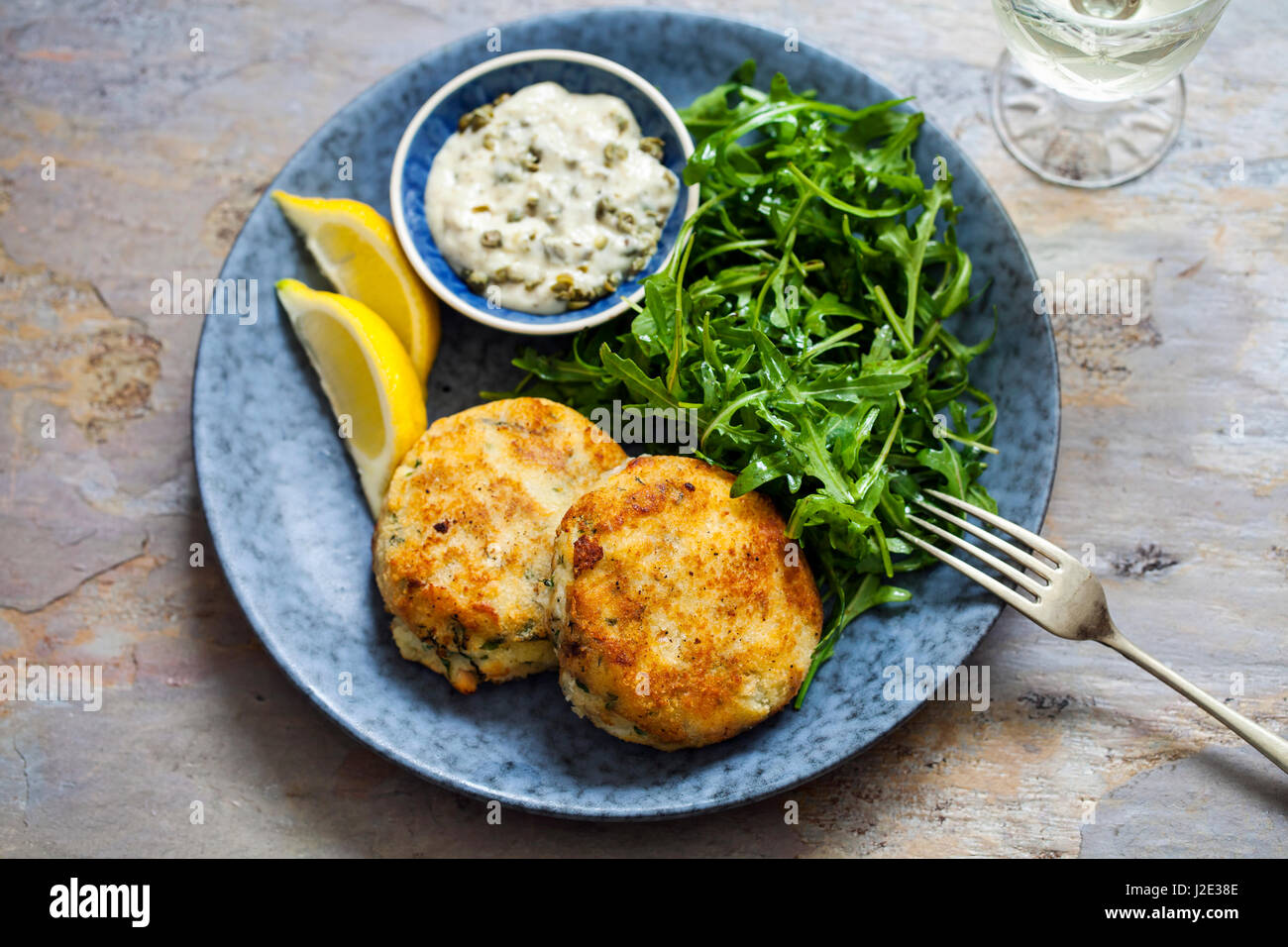 Fish cakes with tartar sauce and rucola salad Stock Photo Alamy