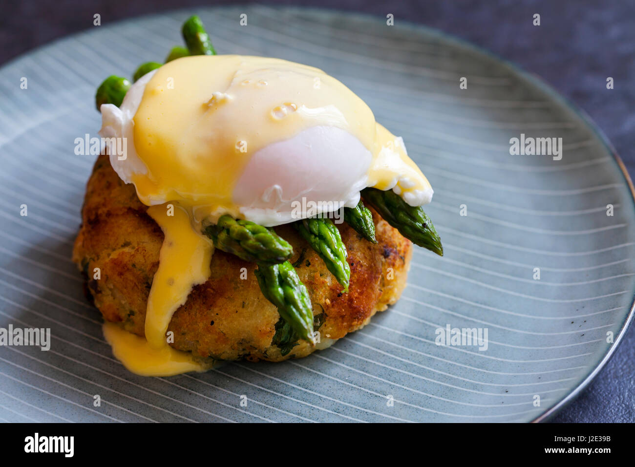 Fish cake with asparagus, poached egg and hollandaise sauce Stock Photo