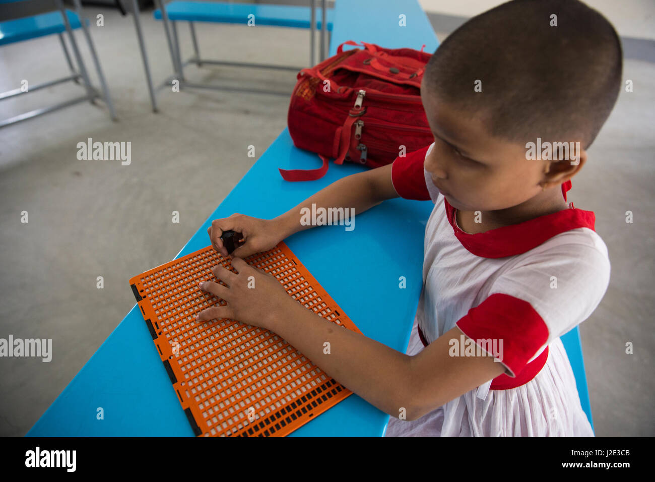 Visually impaired girl student learns in classroom with the help of