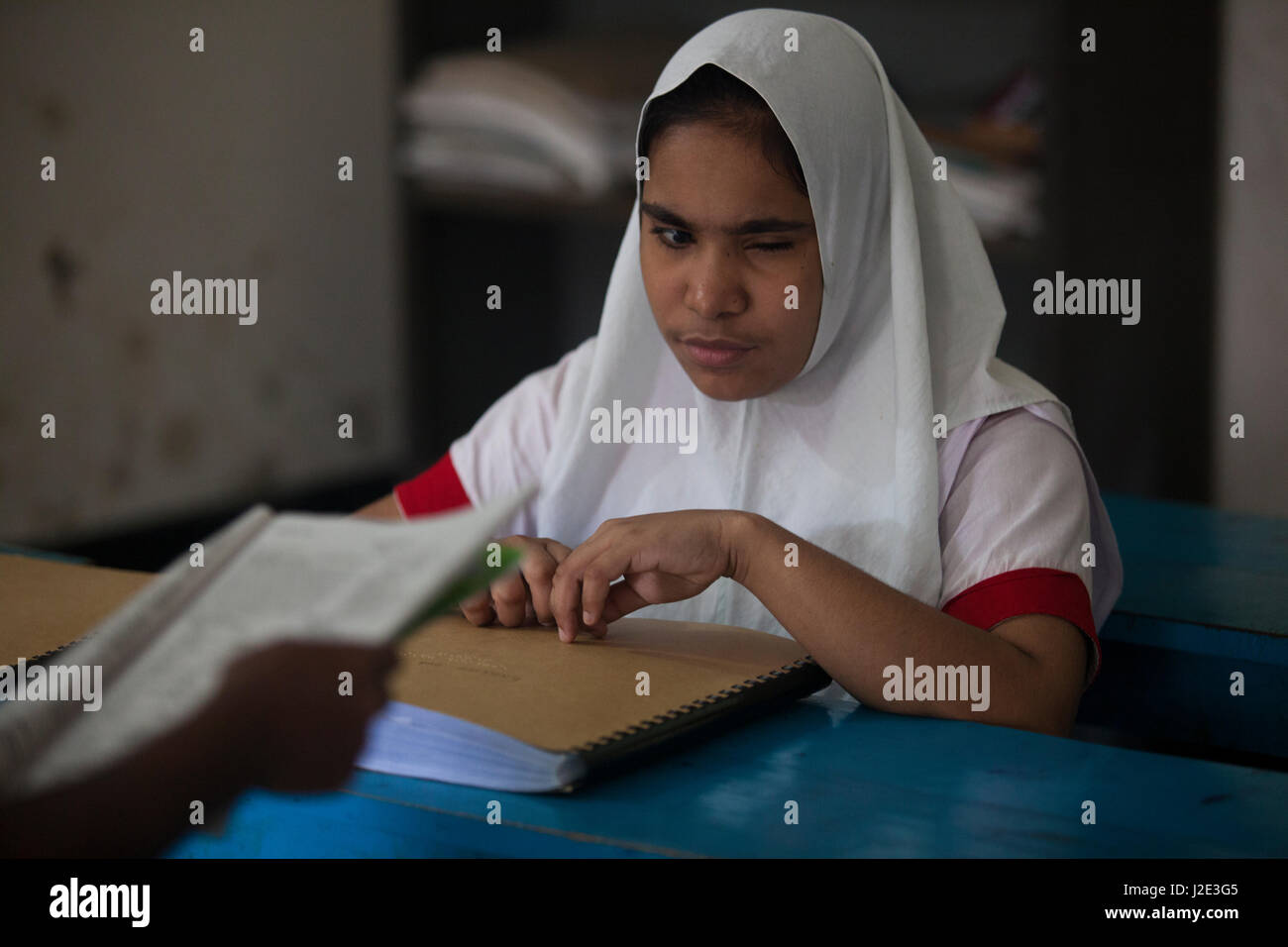 Visually impaired girl student learns in classroom with the help of