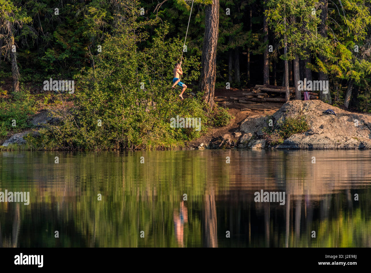 Jumping off a tree rope on a summer day at Champion Lakes Provincial Park, British Columbia, Canada, (MR) (Large format sizes available) Stock Photo