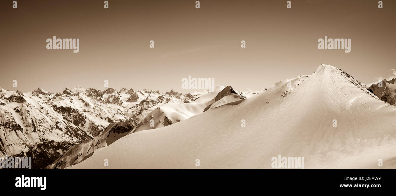 Panoramic view on winter snow mountain. Caucasus Mountain, region Dombay. Slope for freeriding, top of Musa Achitara. Sepia toned landscape. Stock Photo