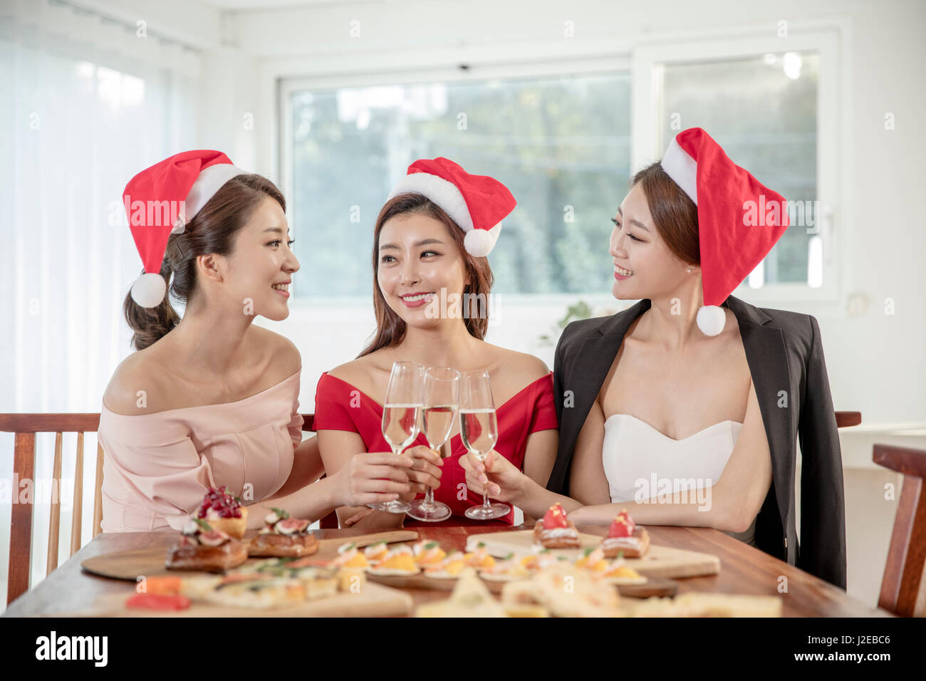 Portrait of three young smiling women at party Stock Photo