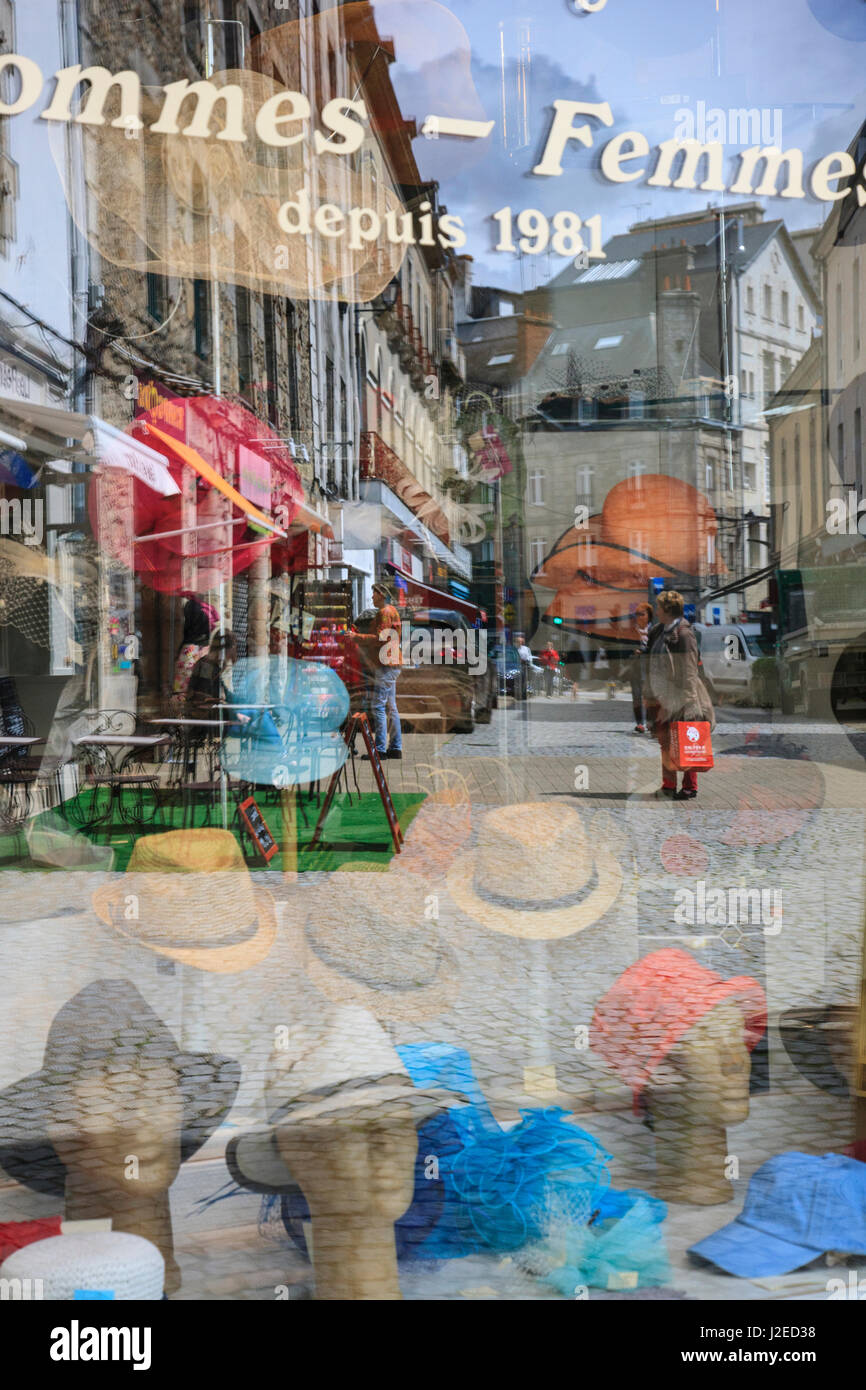 Life on this cobblestoned street in the 2000 year old town of Vannes is reflected in the window of the Chapellerie, the hat store. Stock Photo