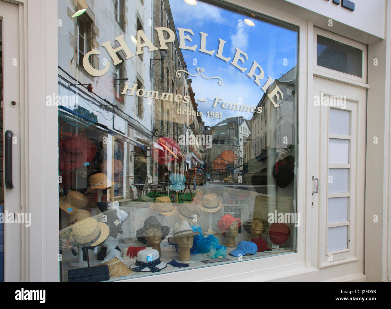 This is the window of store selling hats and scenes of the street reflecting in the window in the 2000 year old town of Vannes, located in Brittany, France. Stock Photo