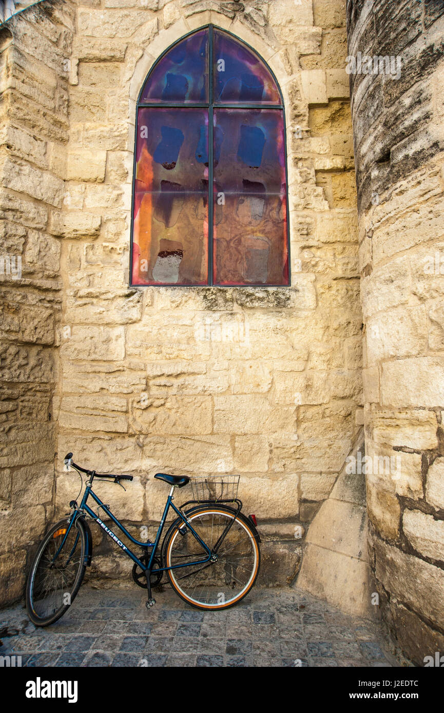 Bicycle against medieval stone church and window in France Stock Photo