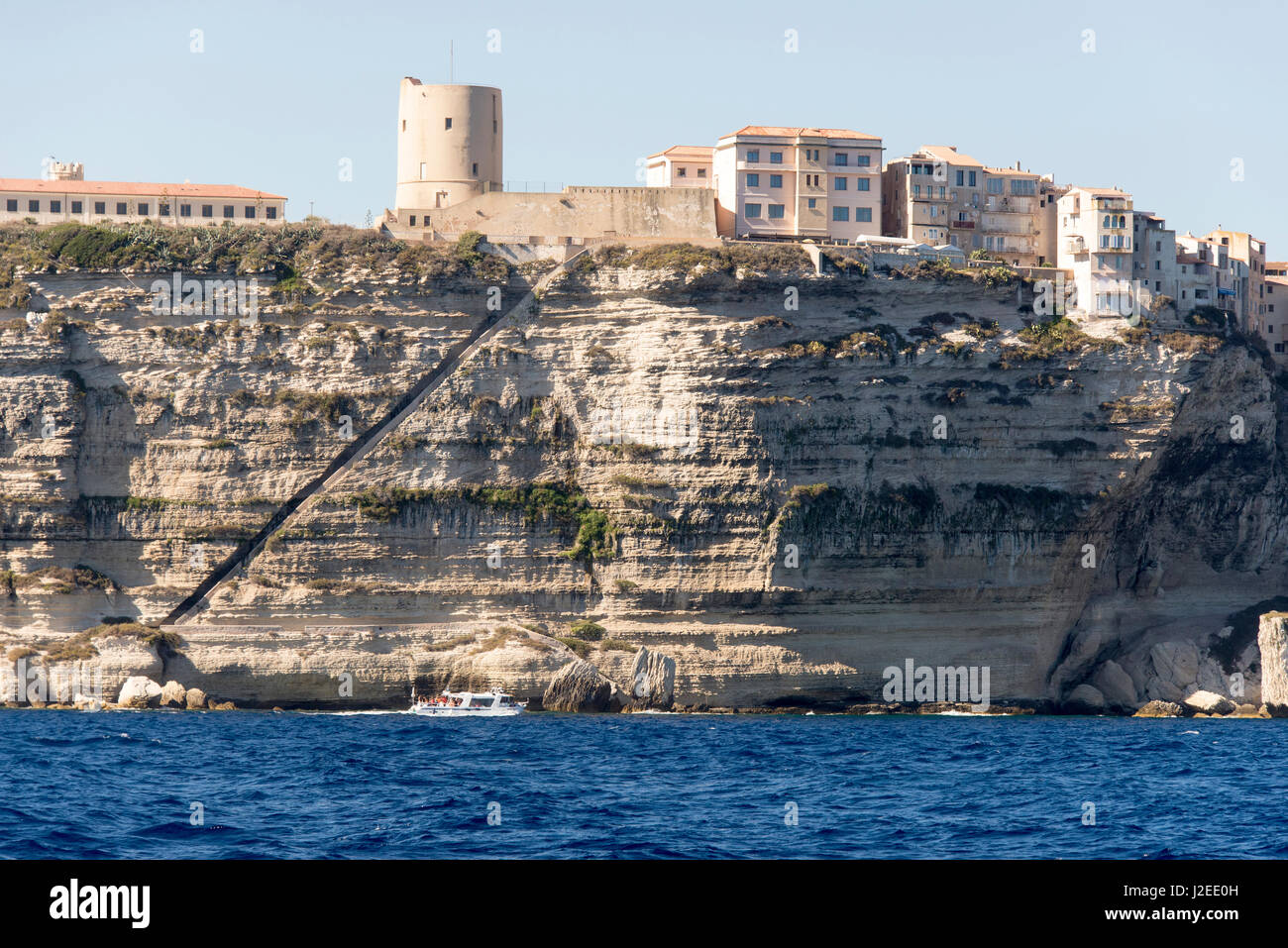 Europe, France, Corsica. Bonifacio cliffs. Tour boat passes stair way carved into side. King Aragon steps (Escalier du Roi d'Aragon) Stock Photo