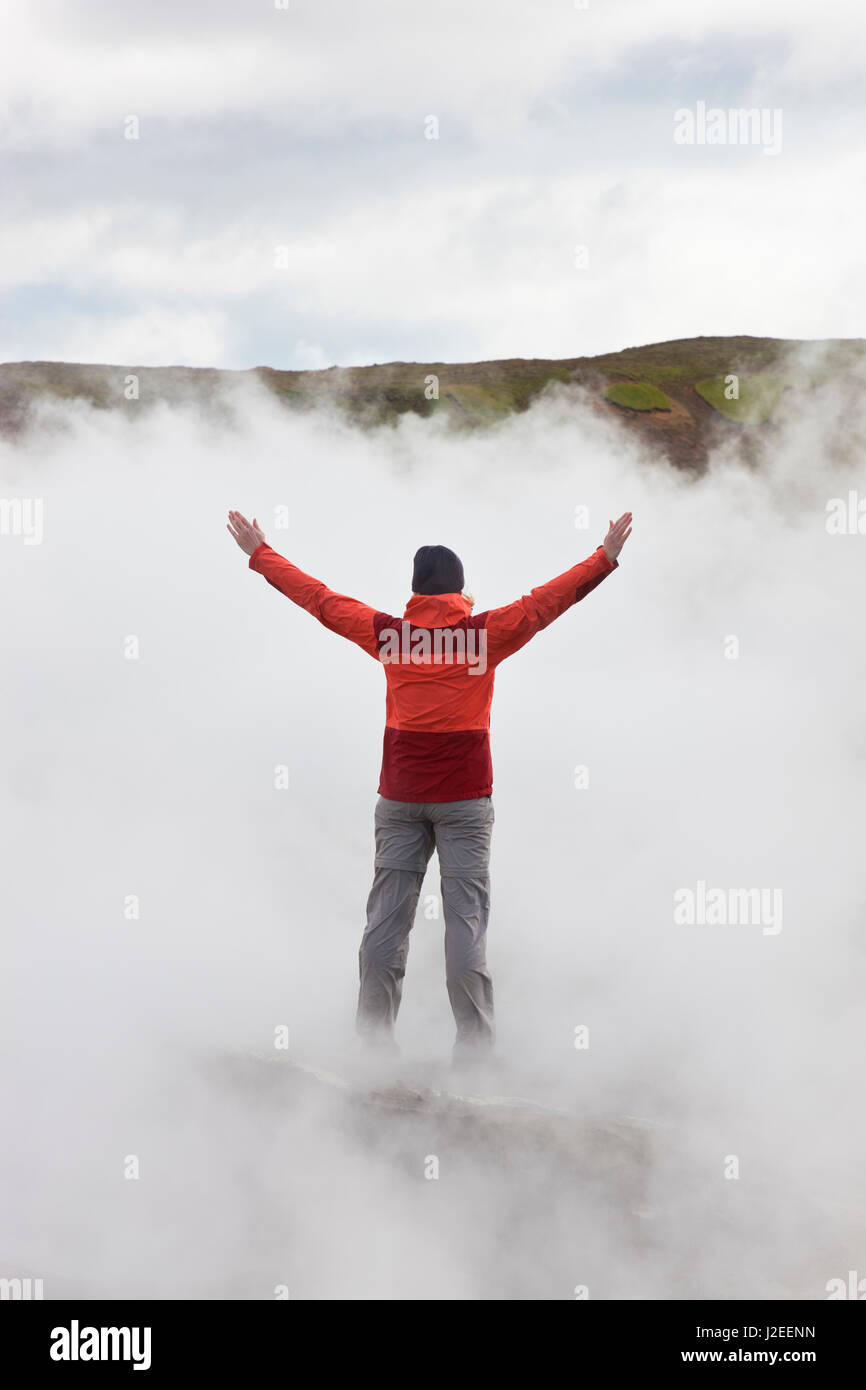 Woman standing by geothermal pools, SW Iceland Stock Photo
