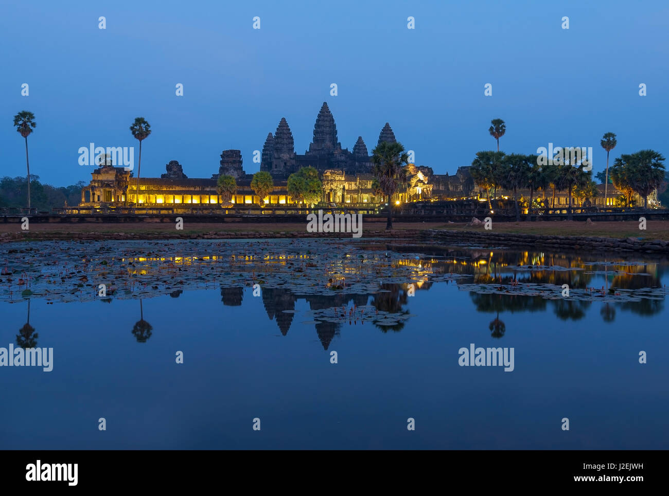 The majestic Angkor Wat ruins at night during twilight, reflected in the man made lake in front of the temple complex near Siem Reap, Cambodia. Stock Photo