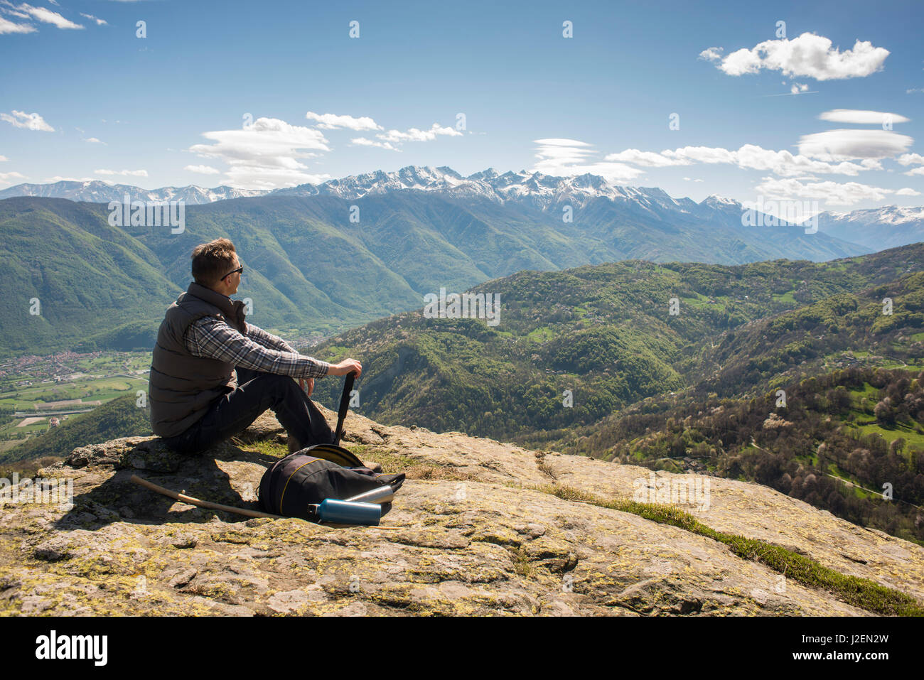 Man Sitting on Top of Mountain with Panoramic View, Mocchie, Piedmont, Italy Stock Photo