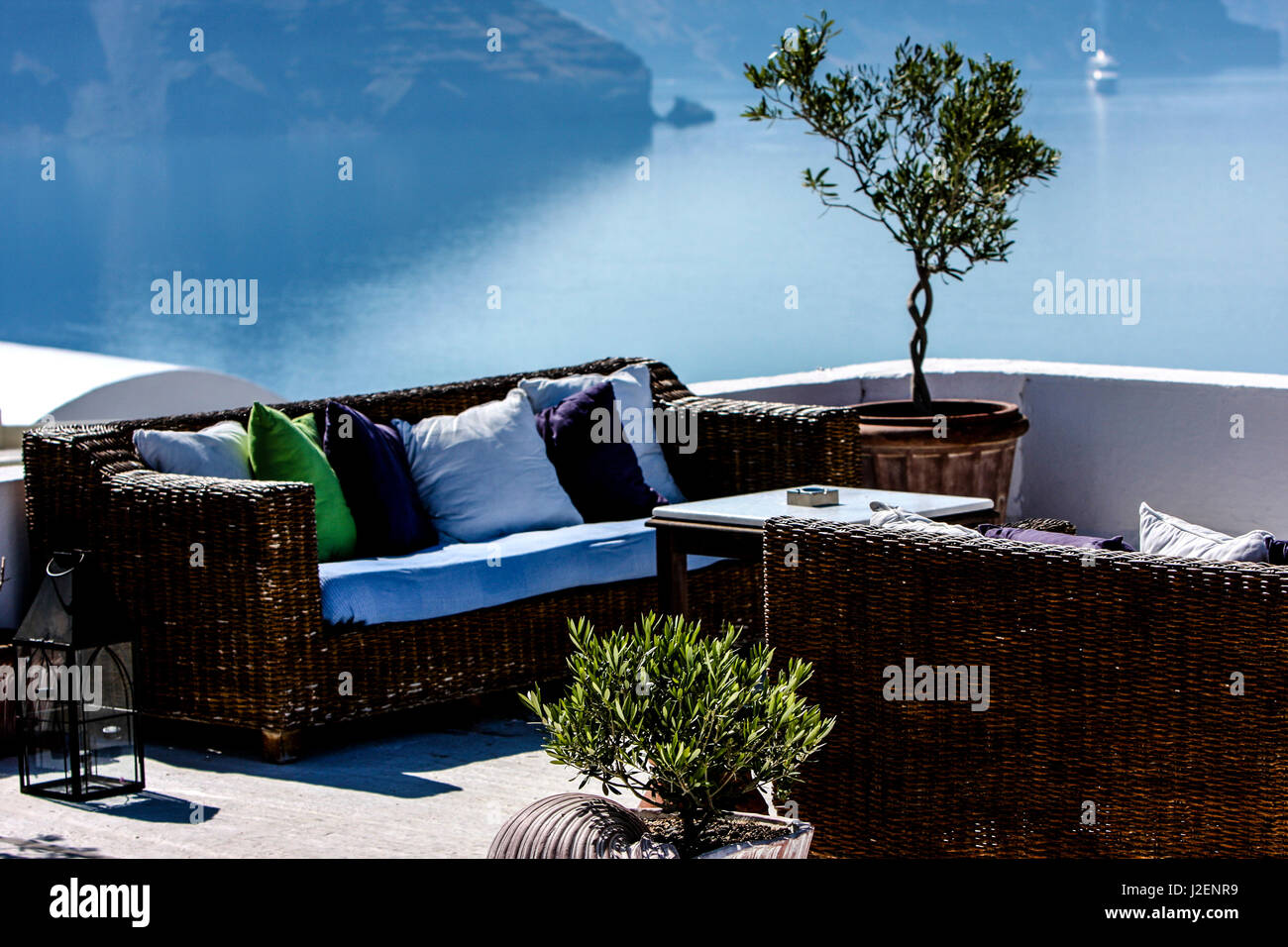 Oia, Santorini, Greece. Rattan wicker patio furniture and seating area overlooking the Aegean