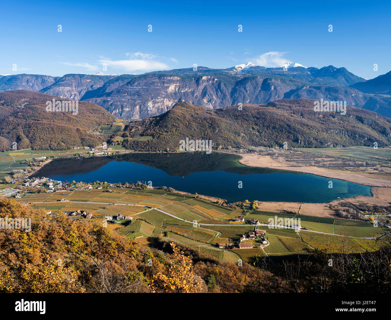 Lake Kalterer See (Lago di Caldaro) during autumn. The Dolomites and the Bletterbach canyon, both Unesco World Heritage Sites in the background. South Tyrol, Italy (Large format sizes available) Stock Photo