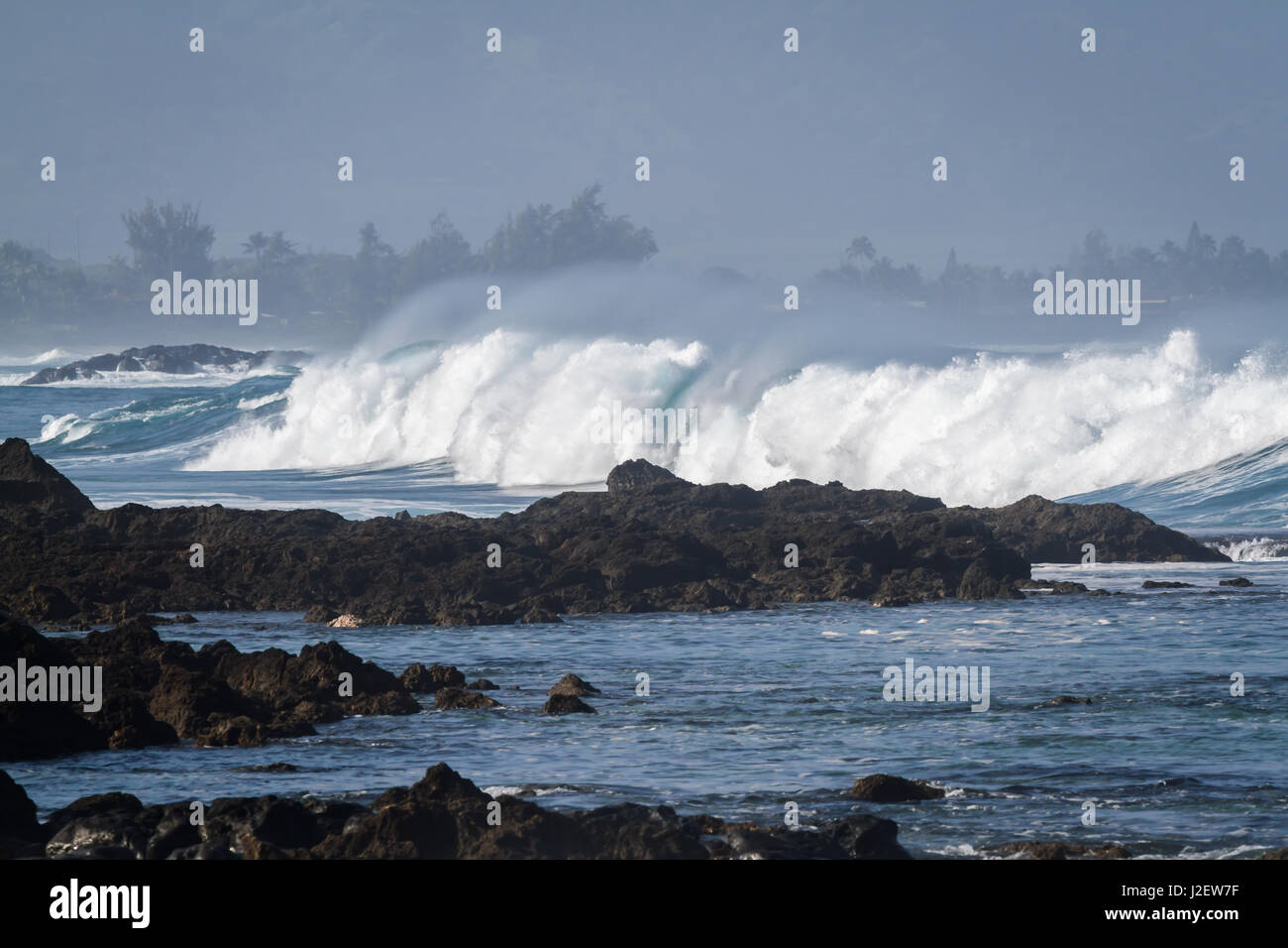 Ocean wave crashing against the rocks at Waimea bay on the north shore