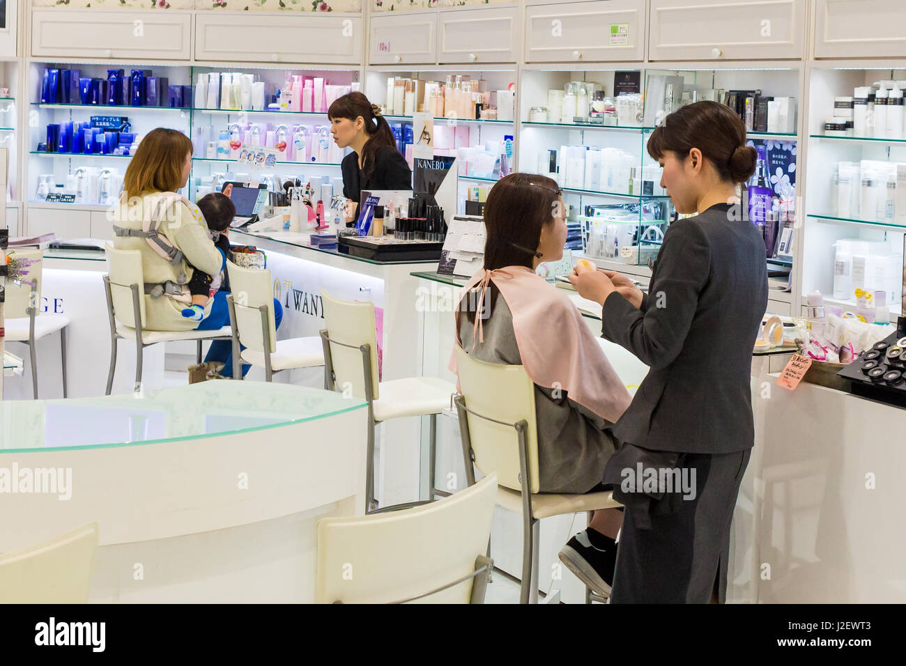 Kanazawa, Japan - March 30th, 2017: Japanese beauty experts doing make up to costumers, inside a cosmetics store in Kamazawa. Stock Photo