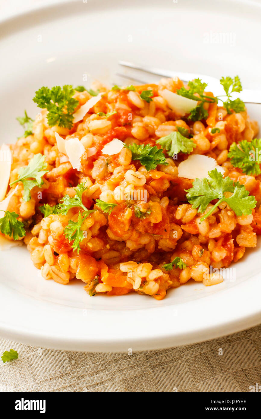 Pearl barley and tomato stew on white platter Stock Photo