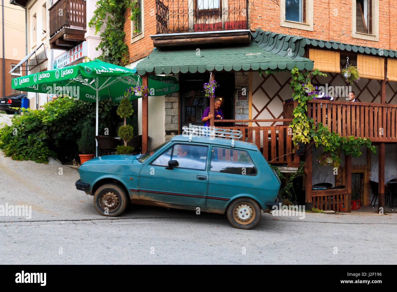 Village of Vevcani is in the Jablanica Mountains, near the town of Struga. Vevcani Springs start here. Gray-blue Yugo car outside restaurant. (Editorial Use Only) Stock Photo