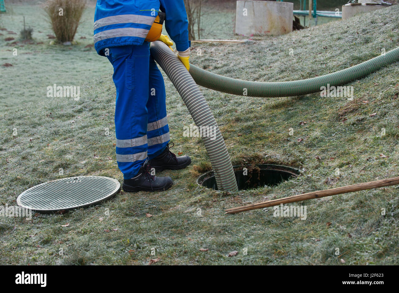 Emptying household septic tank. Cleaning sludge from septic system. Stock Photo