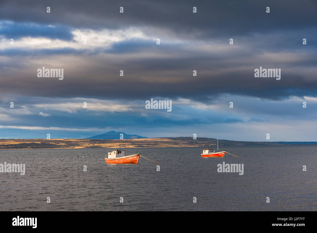 Two fishing boats in early morning light under an angry sky Stock Photo