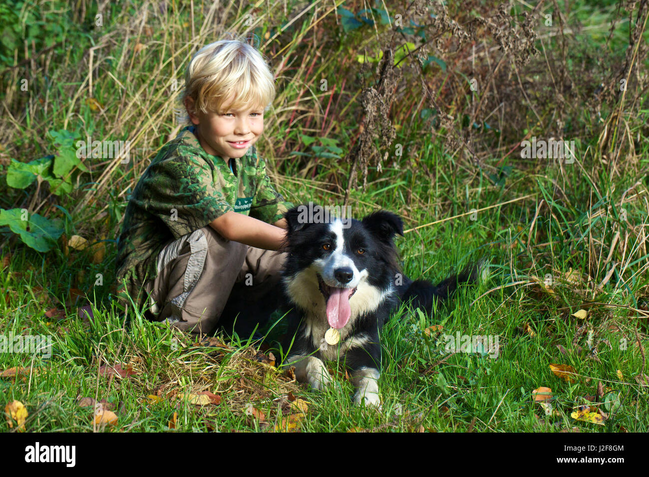 Blond boy with Border Collie Stock Photo