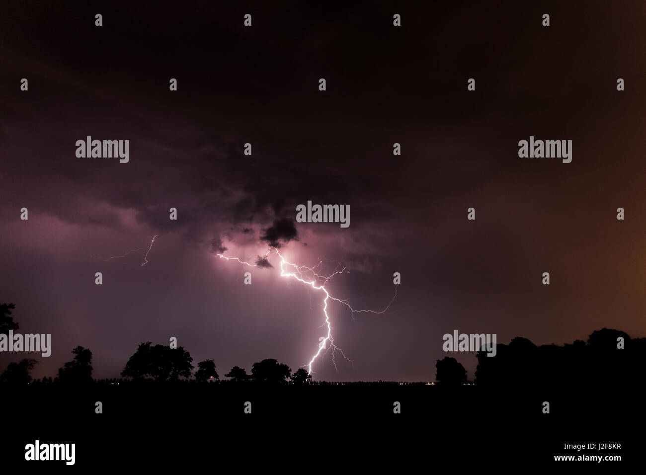 Big lightning strikes in a dark purple sky Stock Photo