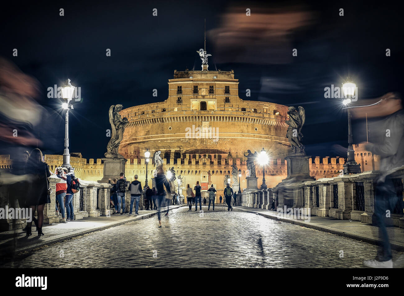 Ponte Sant'Angelo bridge crossing the river Tiber and Castel Sant'Angelo (AD 135), mausoleum of Hadrian, now a museum and art gallery illuminated at n Stock Photo
