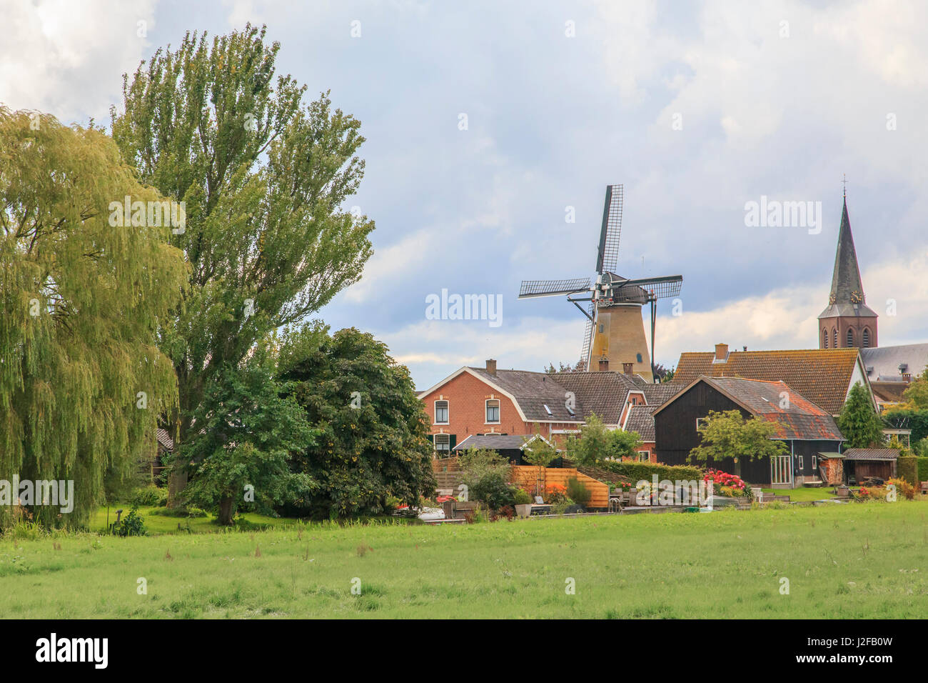 Netherlands, Holland, Utrecht, Wijk bij Duurstede, Cothen. Early 1800's windmill (corn) was steam operated, later electric. Skyline of town characterized by windmill called Oog in 't Zeil (Eye Mill) and Sts. Peter and Paul Church. Stock Photo