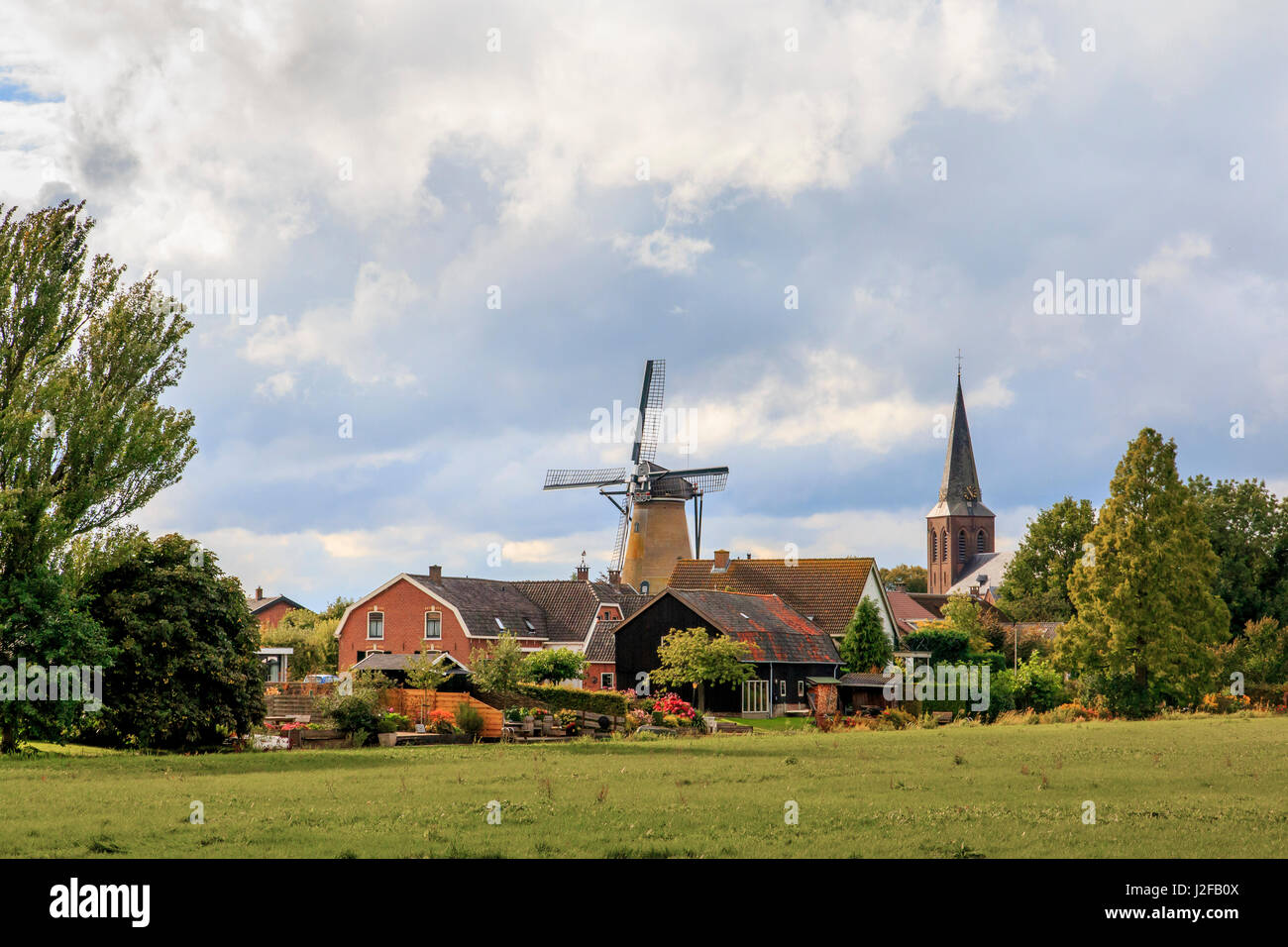 Netherlands, Holland, Utrecht, Wijk bij Duurstede, Cothen. Early 1800's windmill (corn) was steam operated, later electric. Skyline of town characterized by windmill called Oog in 't Zeil (Eye Mill) and Sts. Peter and Paul Church. Stock Photo