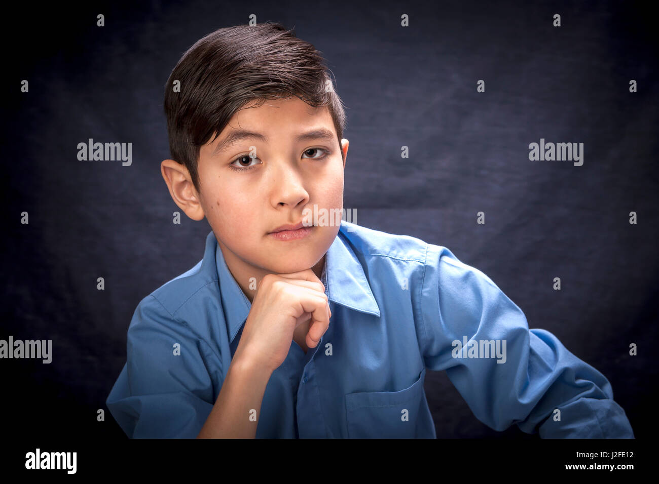 An expression portrait of a young boy raising an eyebrow conveying