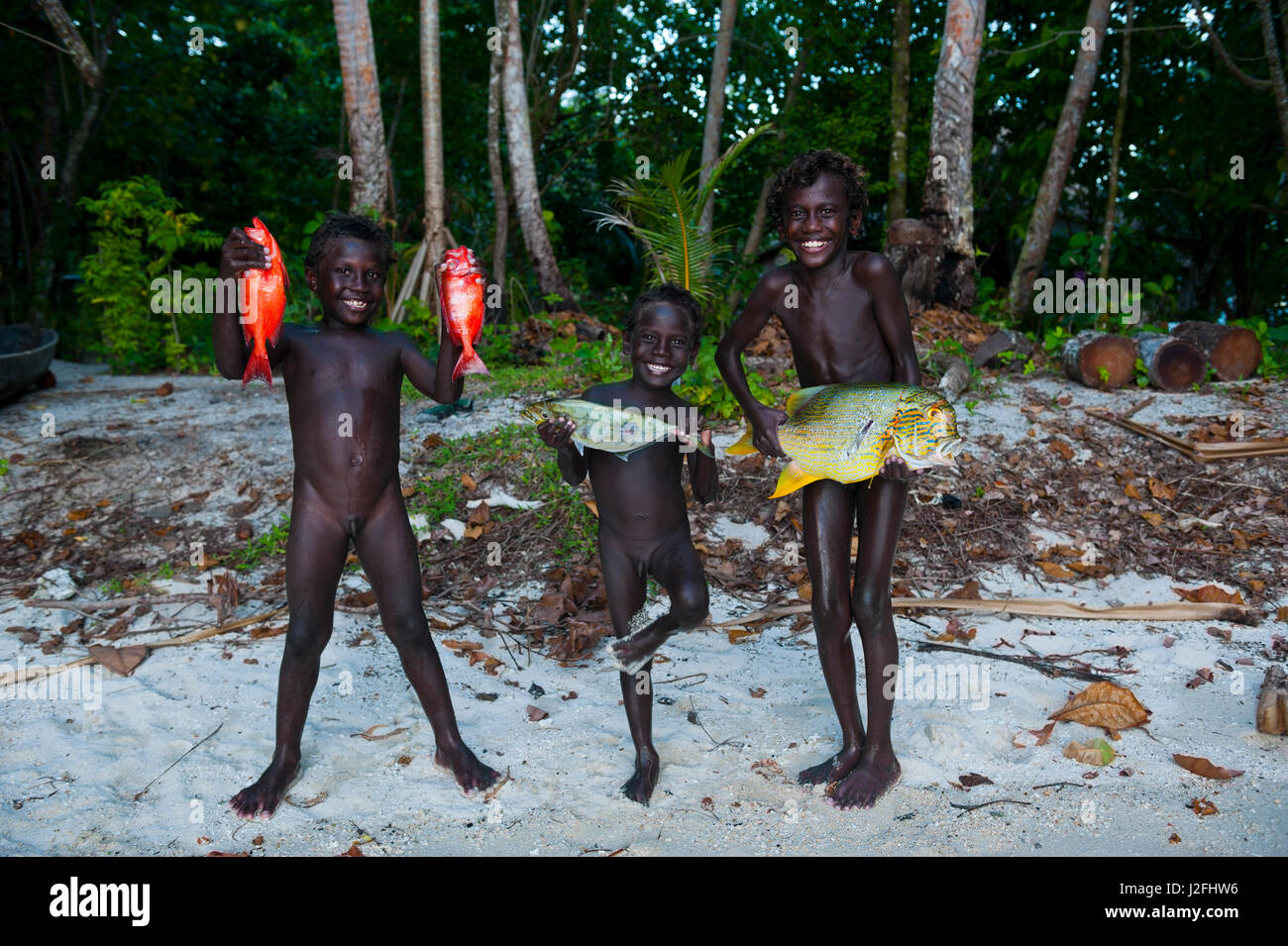 Boys proudly showing their fish they caught in the Marovo Lagoon, Solomon Islands, Pacific Stock Photo