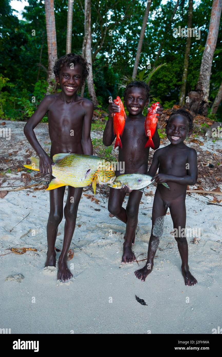 Boys proudly showing their fish they caught in the Marovo Lagoon, Solomon Islands, Pacific Stock Photo