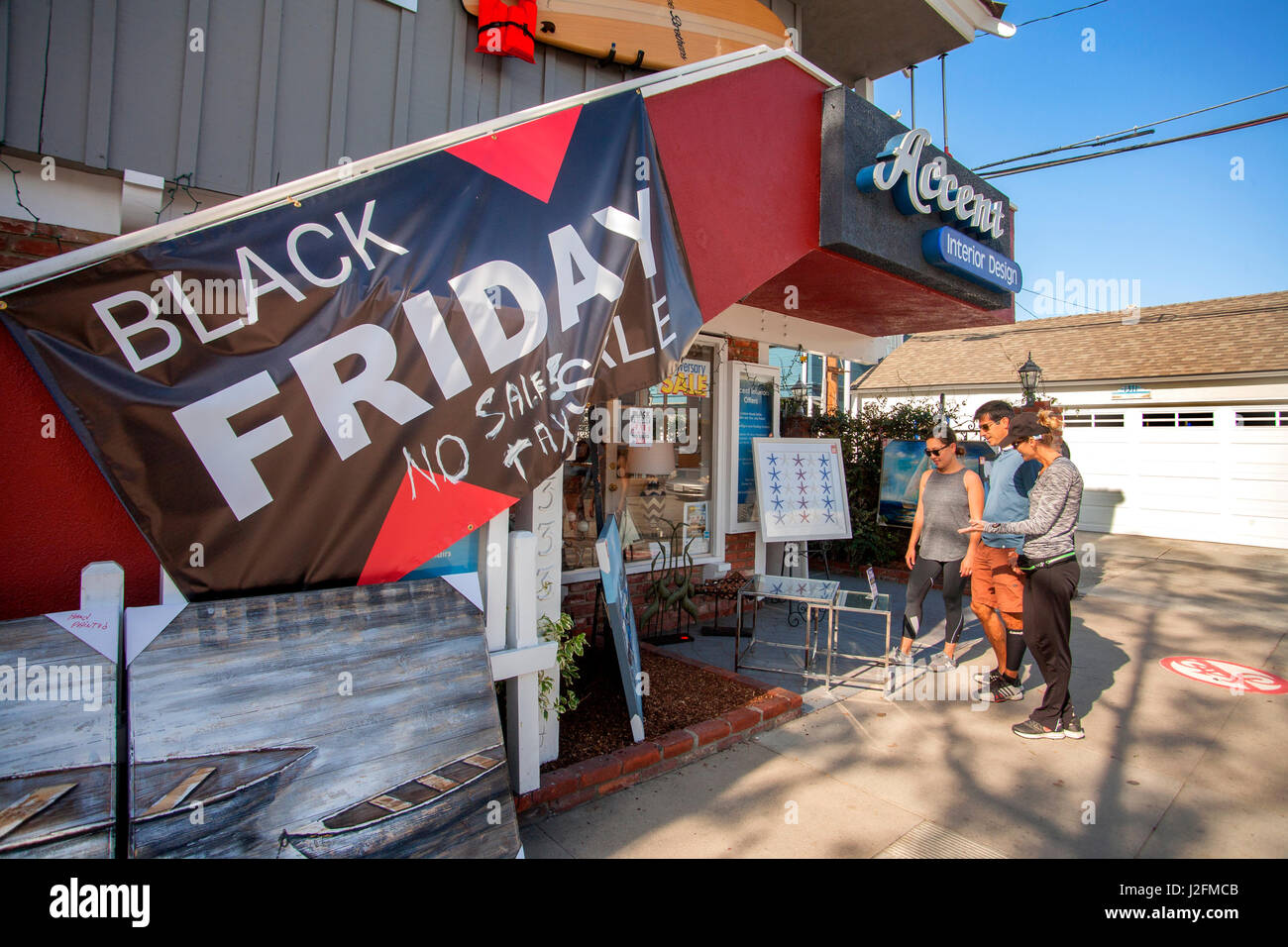 Customers browse an interior design store's paintings while looking for a bargain in discounted merchandise on Black Friday, the first Friday after Thanksgiving, in Newport Beach, CA. Note sign promising no sales tax. Stock Photo