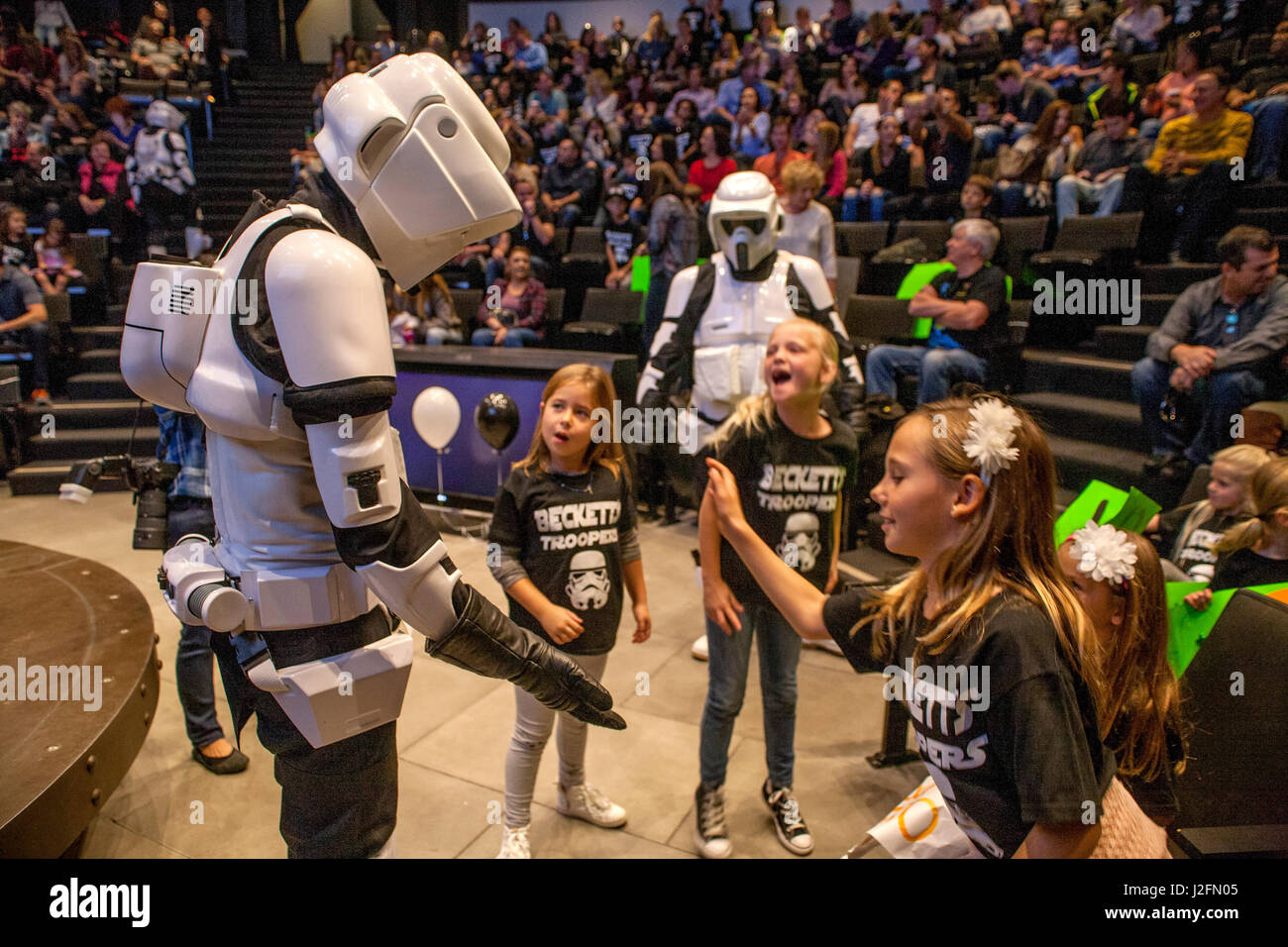 An actor costumed as a Stormtrooper from the futuristic science fiction movie Star Wars exchanges high fives with girls at an amphtheatre in Foothill Ranch, CA. Stock Photo