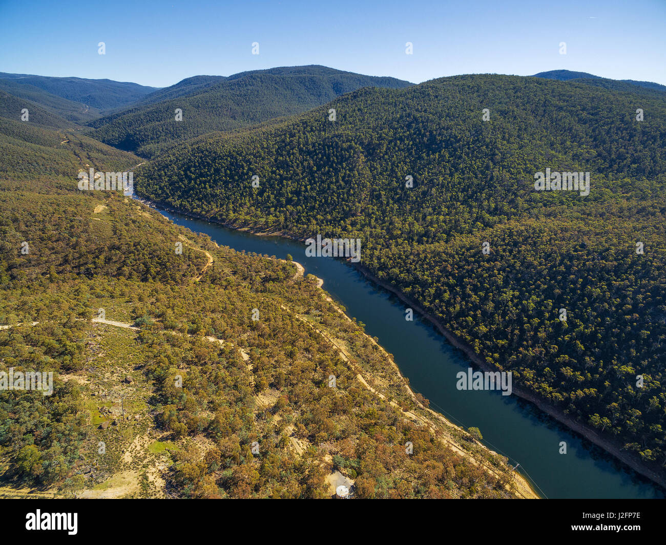 Aerial view of Snowy River flowing among green hills of Australian Alps ...