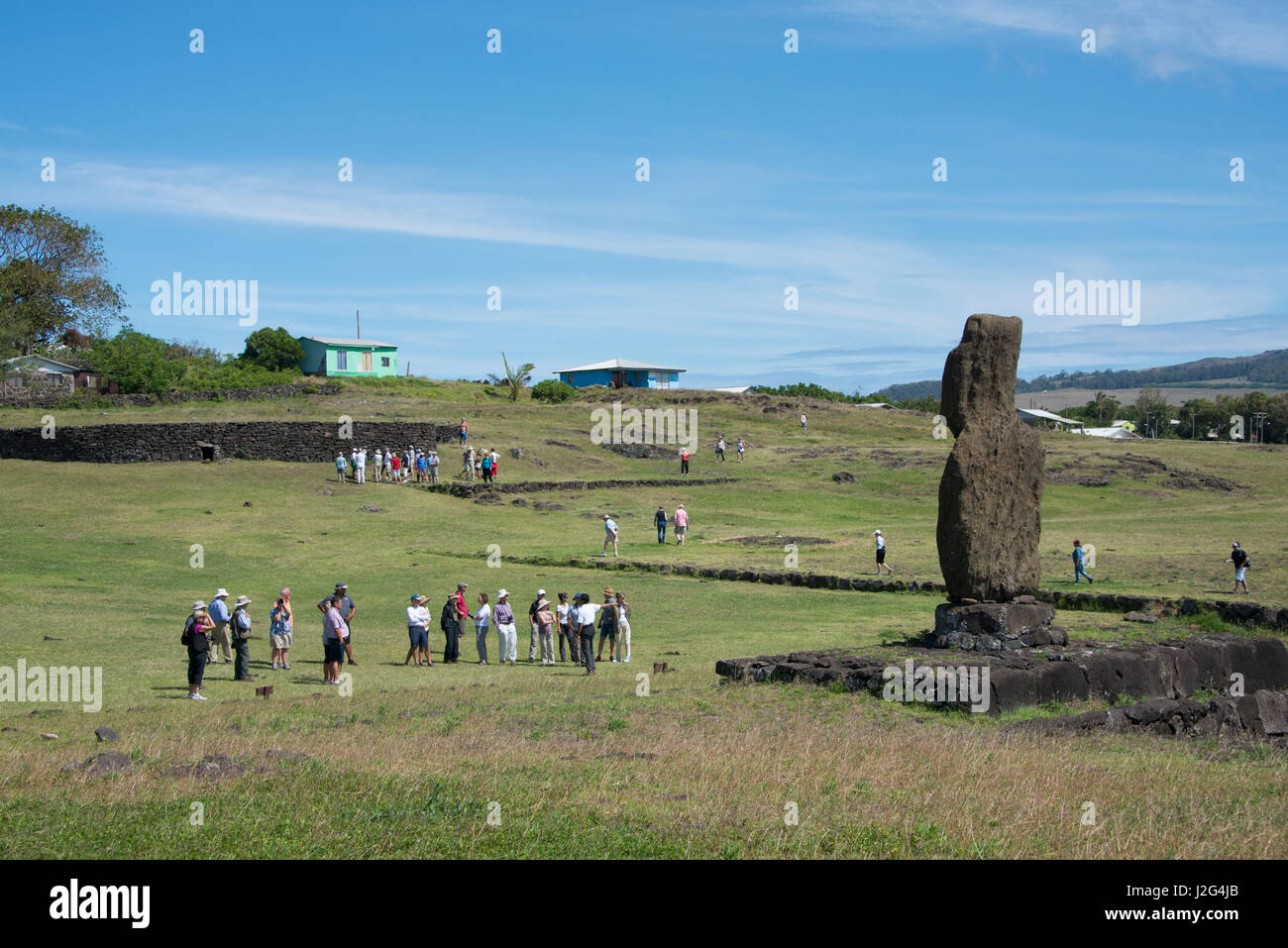 Chile, Easter Island aka Rapa Nui, Hanga Roa. Rapa Nui National Park. Ahu Tahai, a lone well weathered standing moi surrounded by tourists. (Large format sizes available) Stock Photo