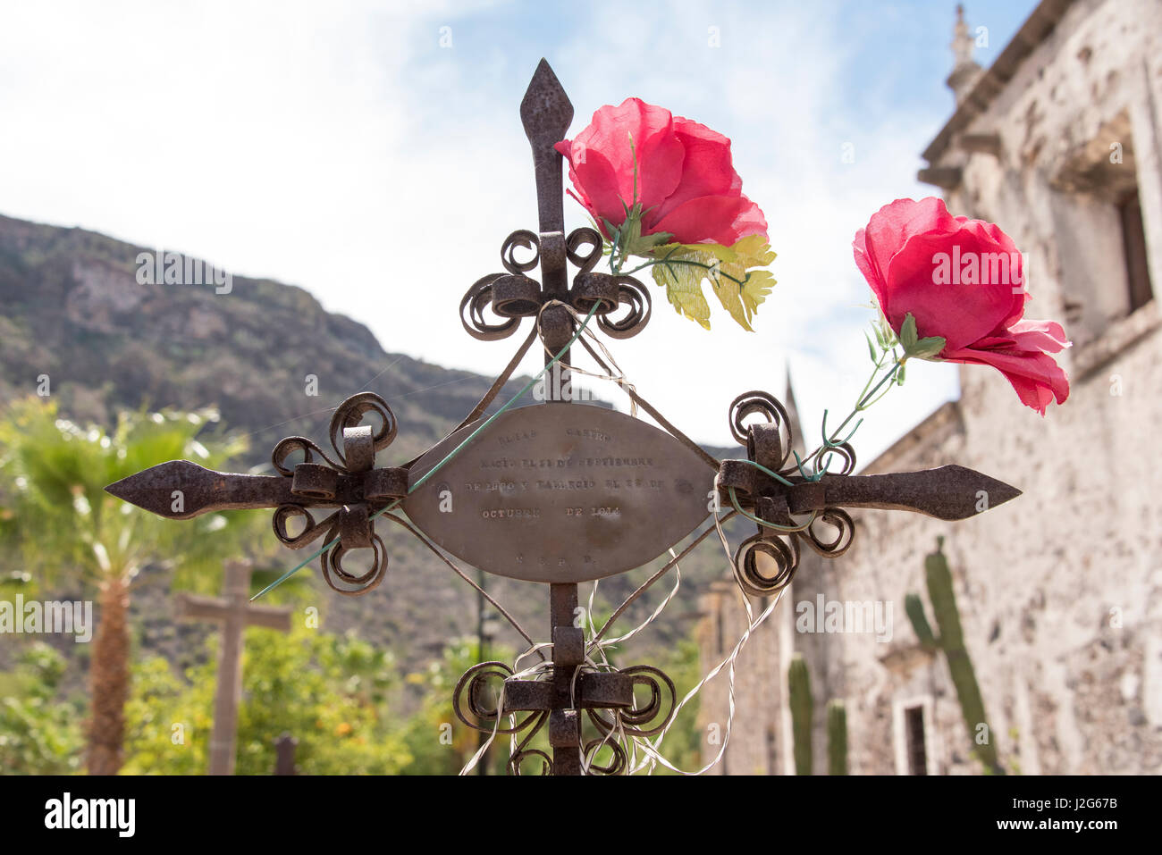 Mexico, Baja California Sur. Mission San Javier, Roman Catholic Jesuit. Founded 1699 closed 1817 Grave marker with iron work and flowers Stock Photo