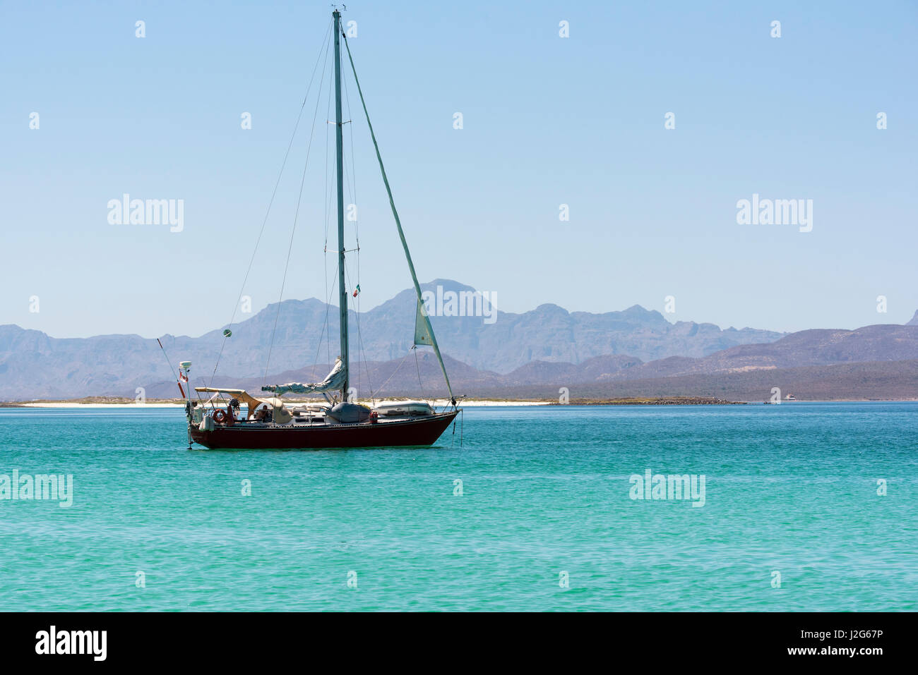 Mexico, Baja California Sur, Sea of Cortez, Loreto Bay. Lone sailboat on flat calm water Stock Photo