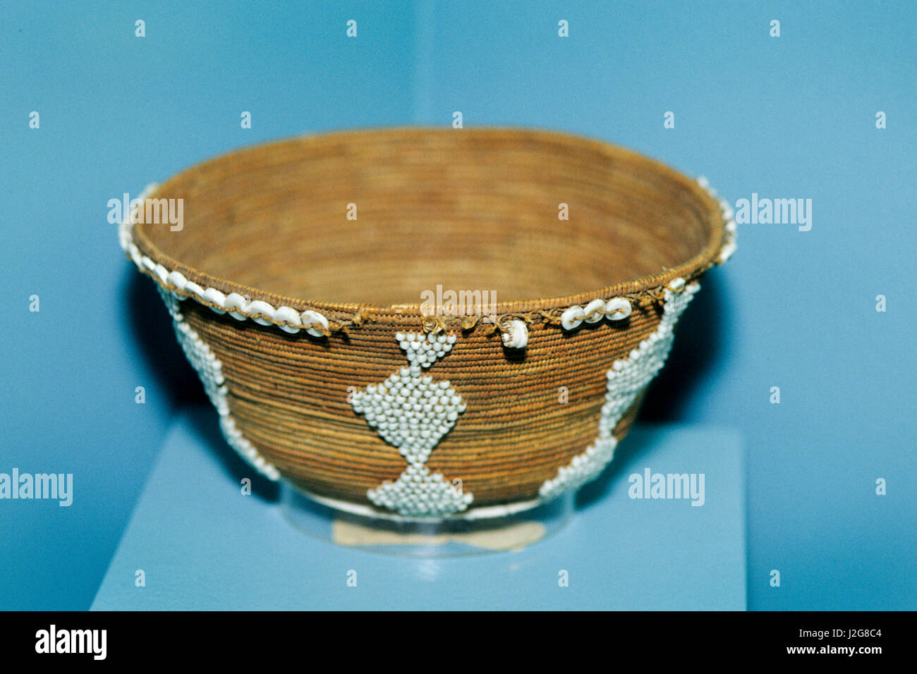 Pomo jewel basket decorated with puka shells and white seed beads. Stock Photo