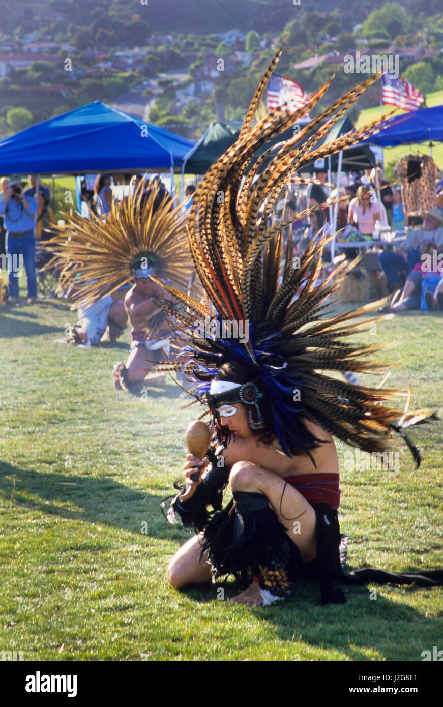 Traditional Aztec men dance around a fire and honor their ancestral Gods during a ceremonial presentation at a gathering in Malibu Beach California Stock Photo