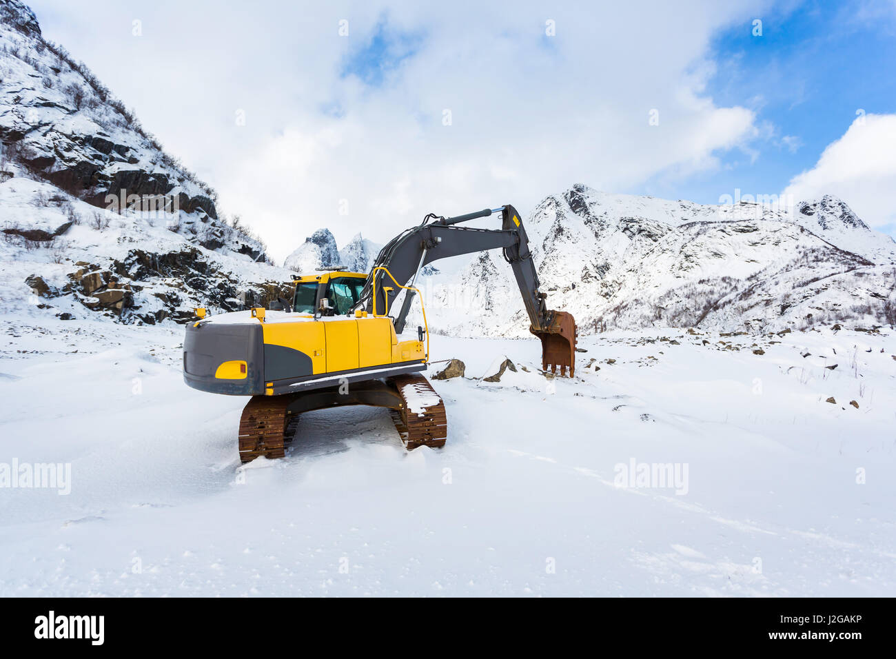 Excavator in the snowy mountains of Lofotens, Norway Stock Photo