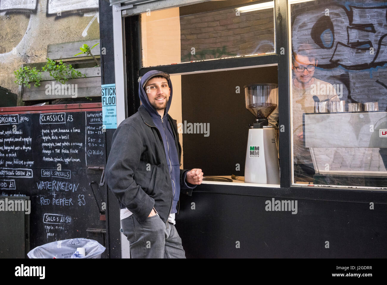 A man enjoying a coffee at a coffee shop on Rye Lane. Photographs from