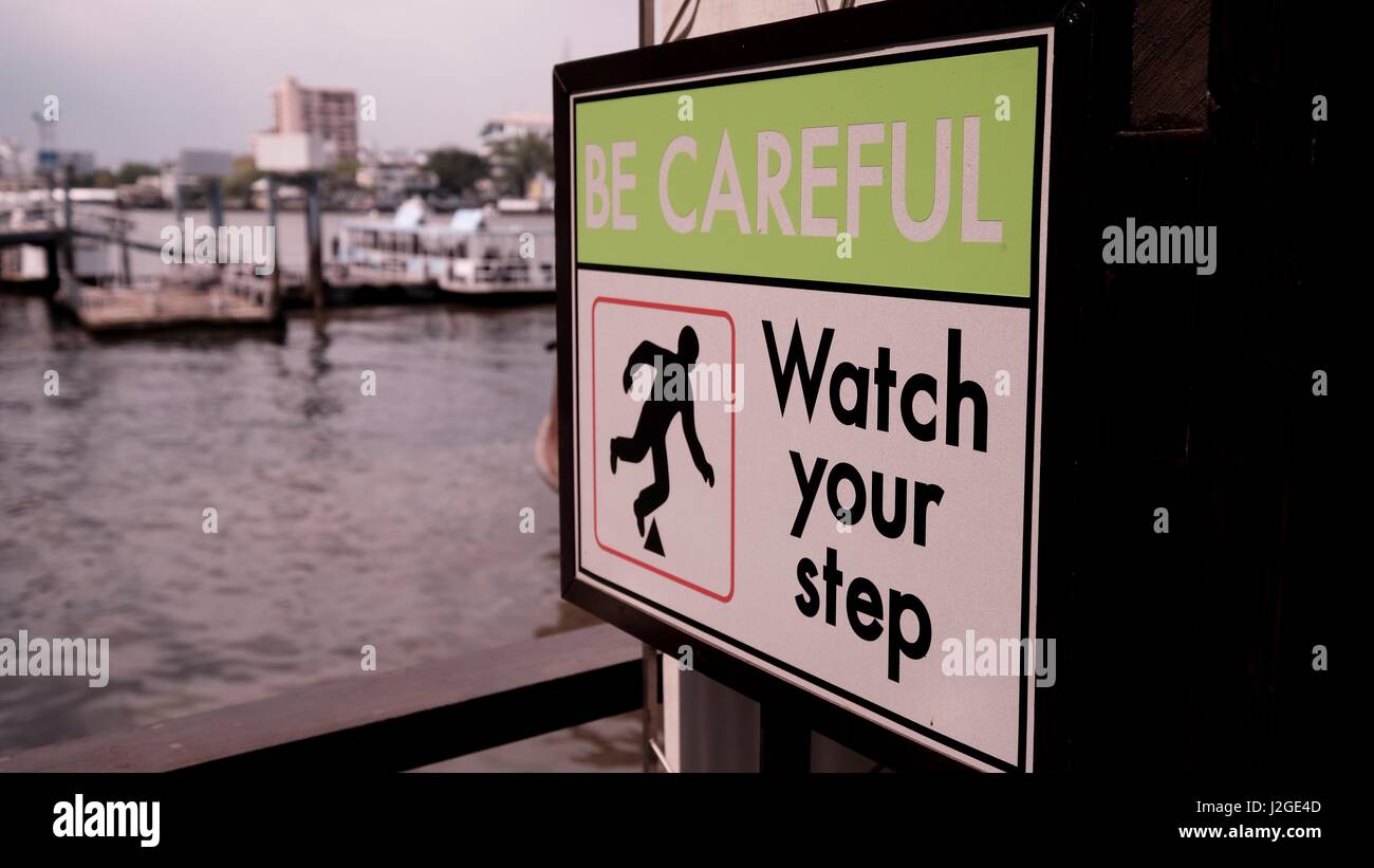Watch Your Step Boat Dock Sign on Chao Phraya River Dock Stock Photo