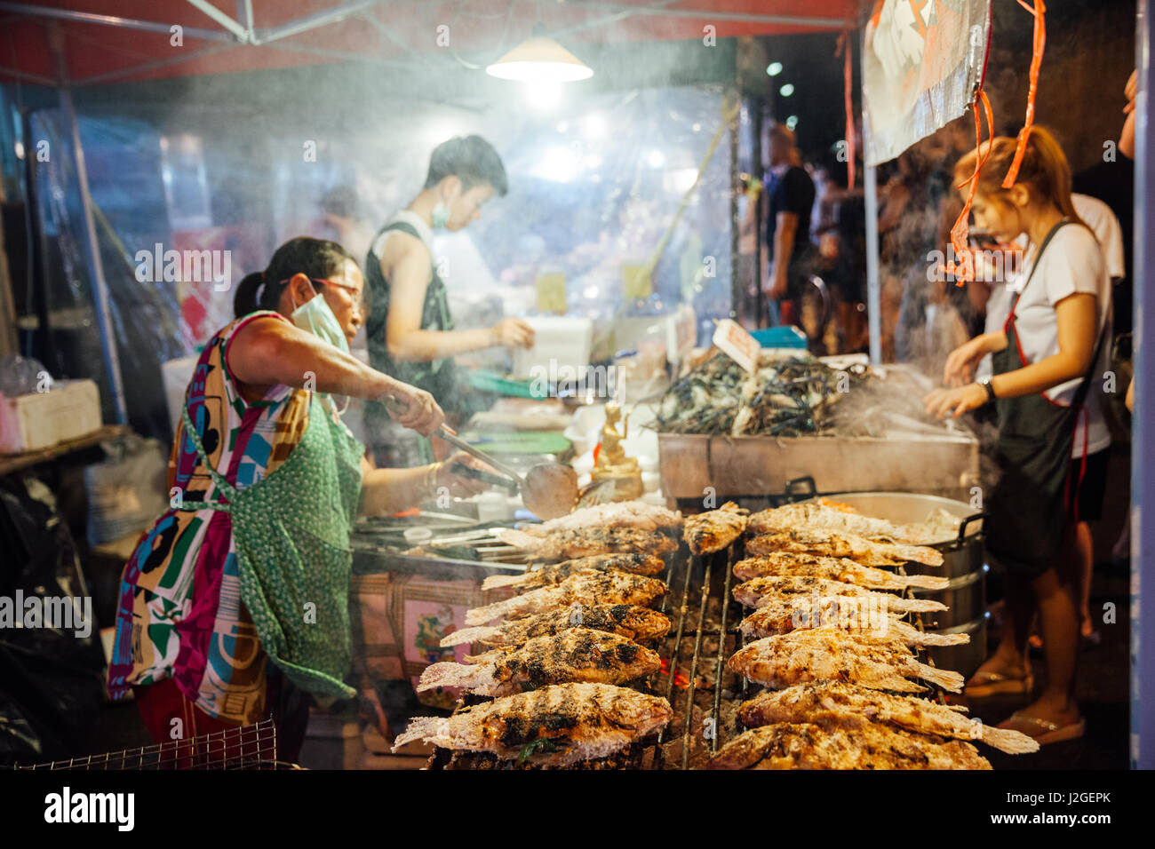 CHIANG MAI, THAILAND - AUGUST 27: Food vendor cooks fish and seafood at the Saturday Night Market (Walking Street) on August 27, 2016 in Chiang Mai, T Stock Photo