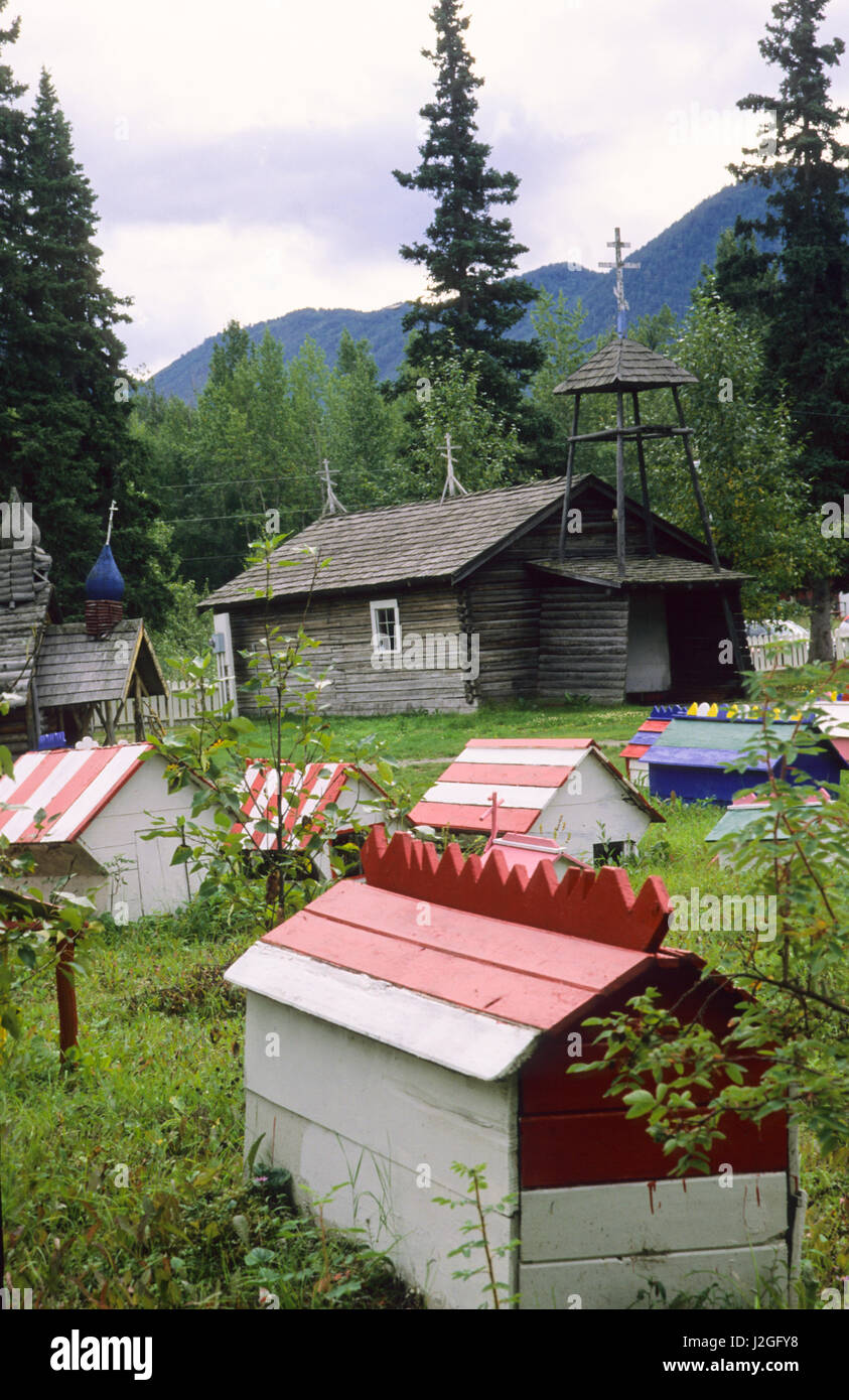 Historic log chapel in sits among painted house grave markers at the