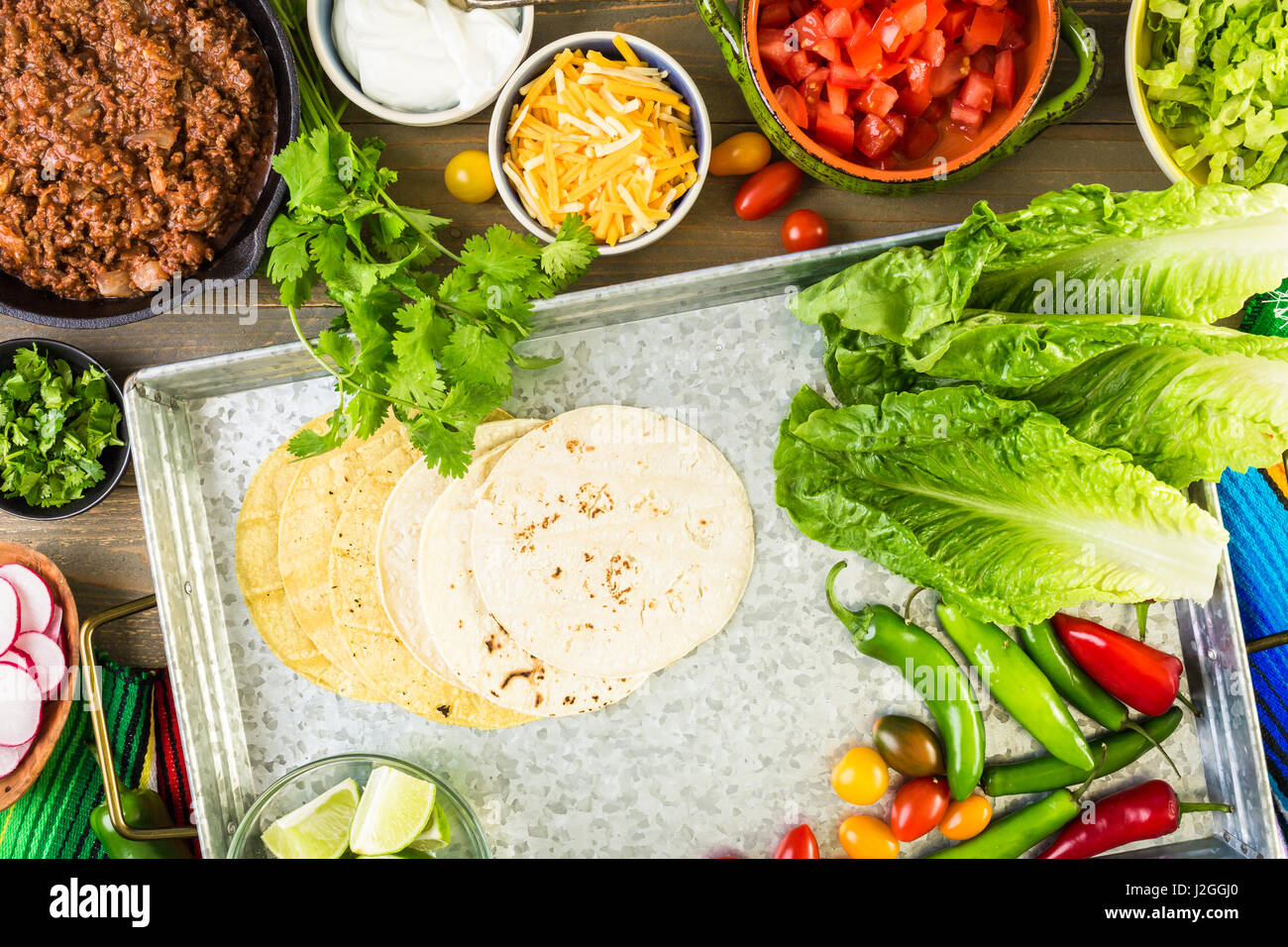 Ground beef tacos with romaine lettuce, diced tomatoes, radished, and