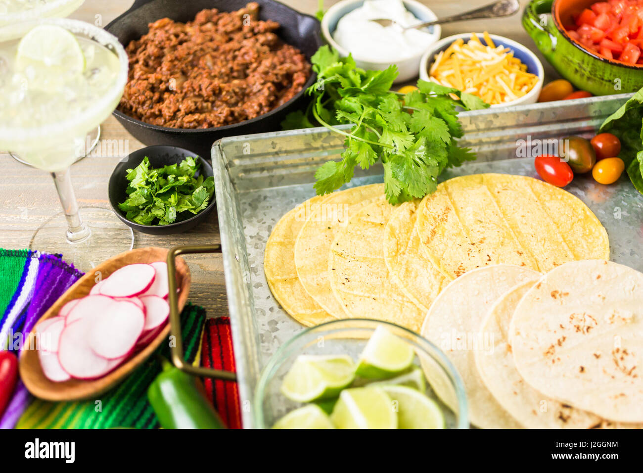 Ground beef tacos with romaine lettuce, diced tomatoes, radished, and