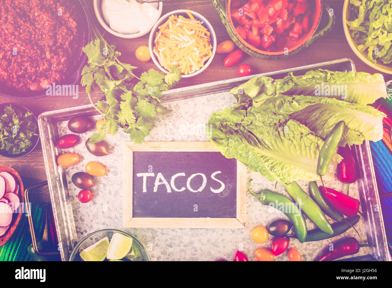 Ground beef tacos with romaine lettuce, diced tomatoes, radished, and